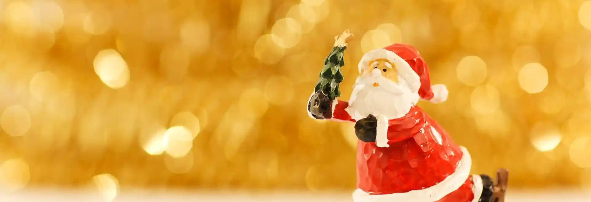 A festive Santa figurine skating gracefully, set against a backdrop of golden holiday lights.